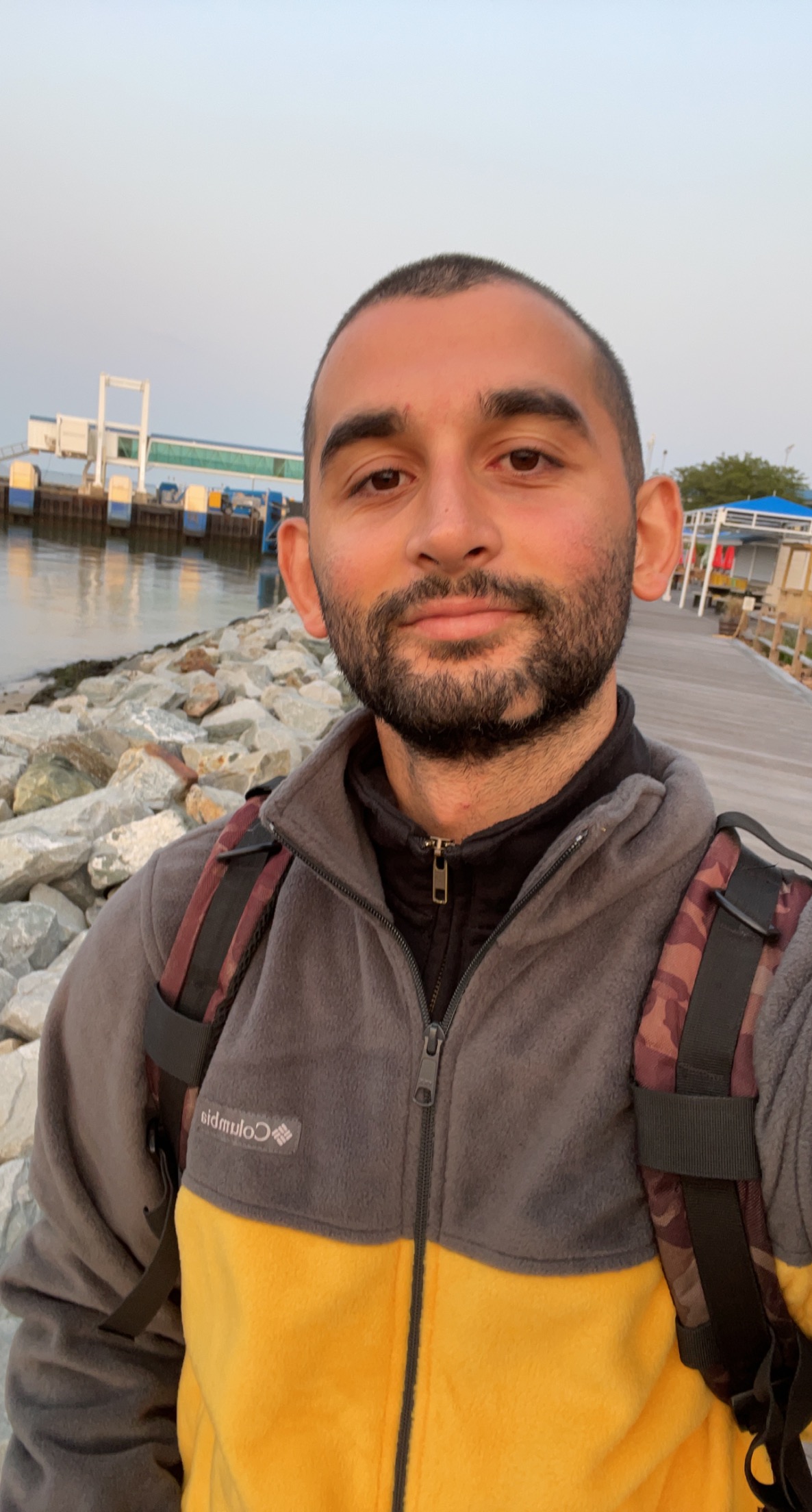 Emre Can Aslan outdoor portrait near a waterfront during his PhD research period